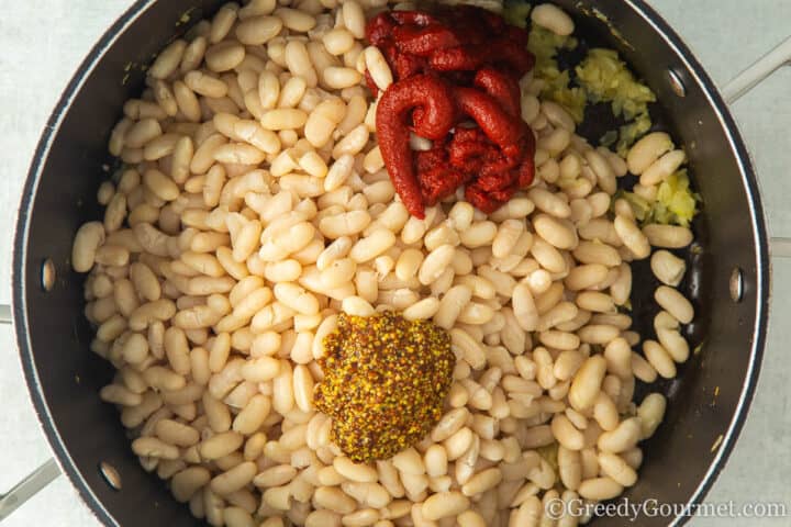 add beans, tomato puree, garlic and mustard to pot.