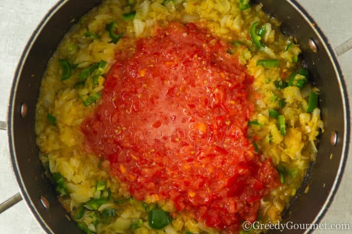add in chopped tomatoes to softened onions.