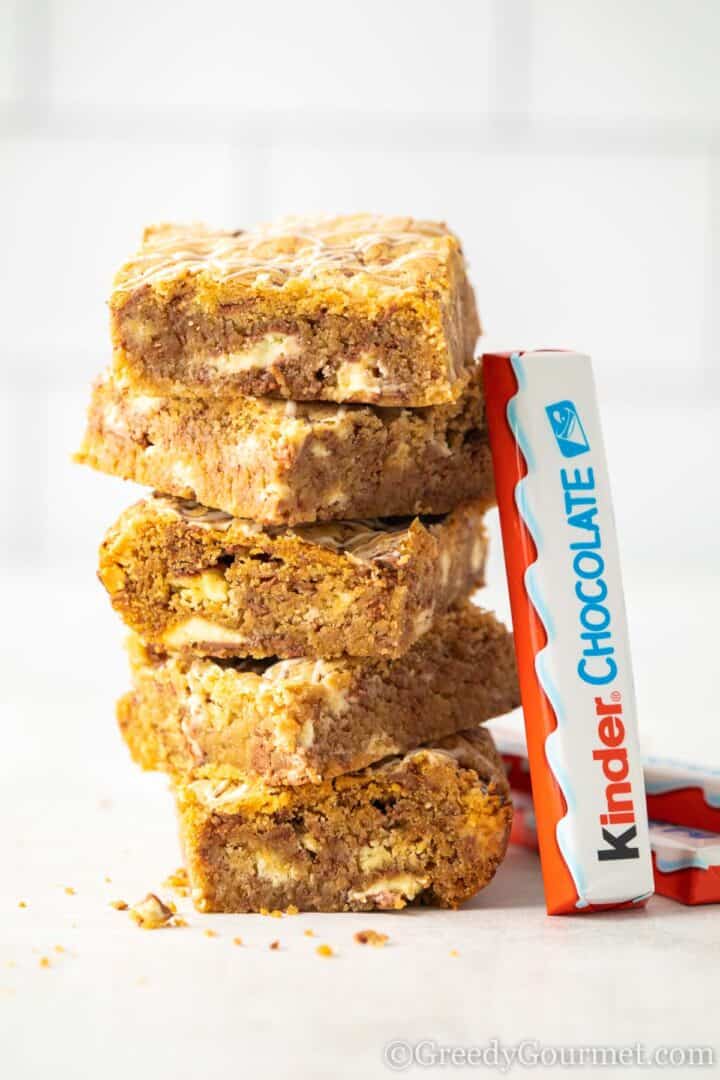 kinder cookie bars in a pile with bar of kinder chocolate leaning against it.