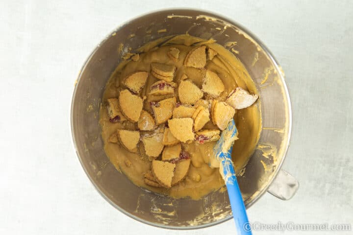 mixing in quartered Jammie dodgers into batter.