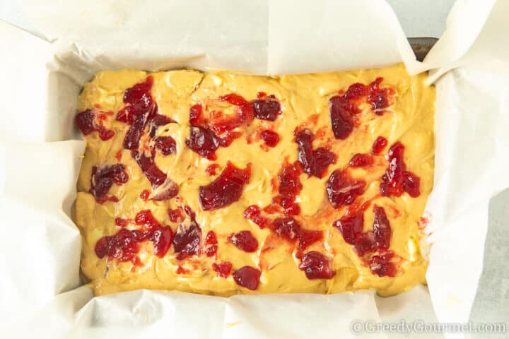 putting jam over blondie batter.