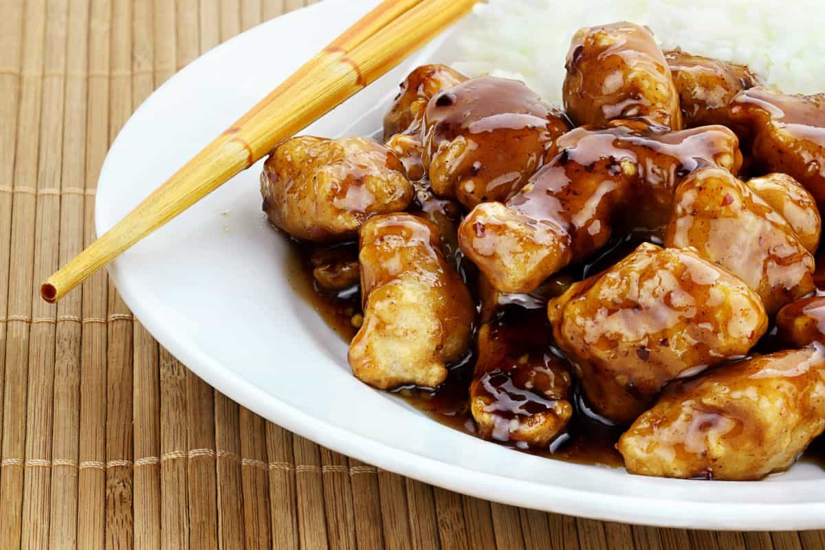 general tso chicken and rice with chopsticks.