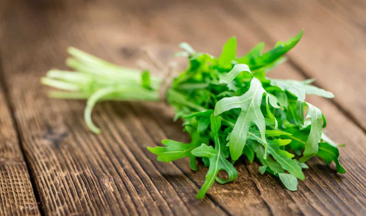 bunch of arugula on a table.