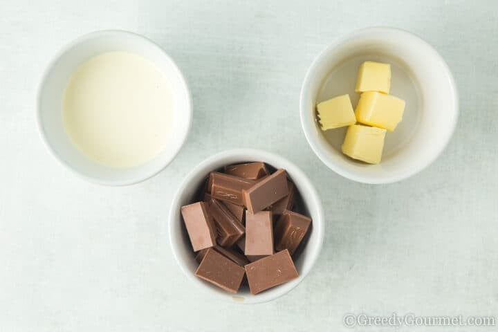 Butter cream and chocolate in small dishes on a table.