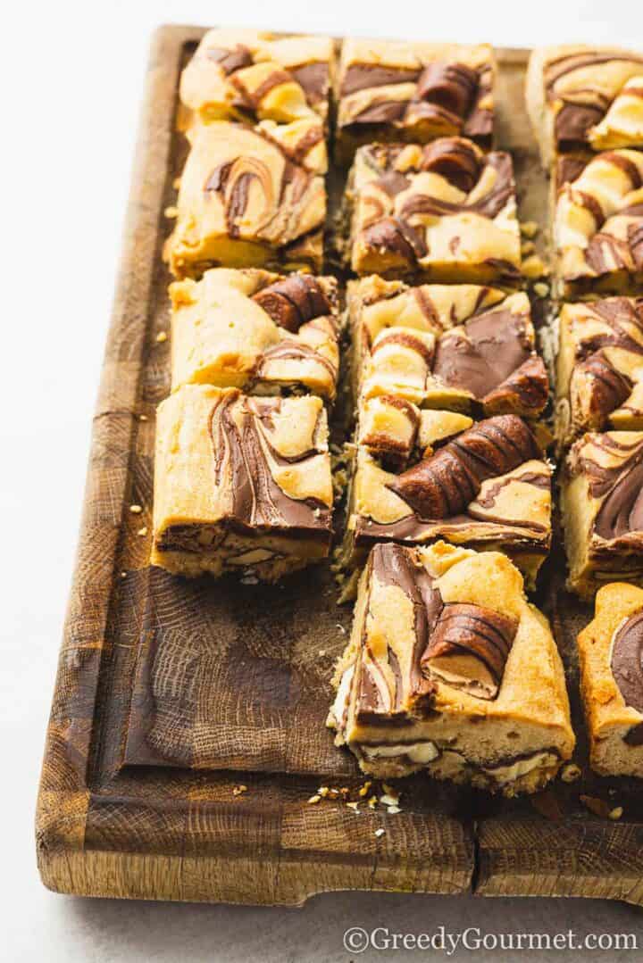 kinder blondie squares on a wooden serving board.