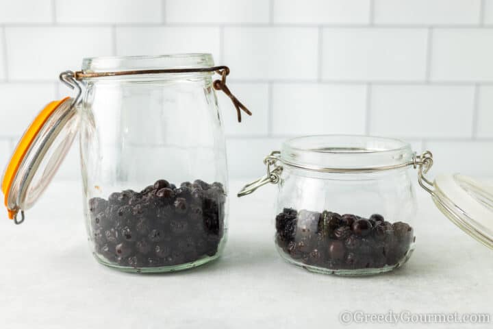 sloe berries in a glass jar.