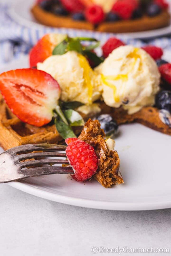 Plate with a waffle, ice cream and fresh fruit.