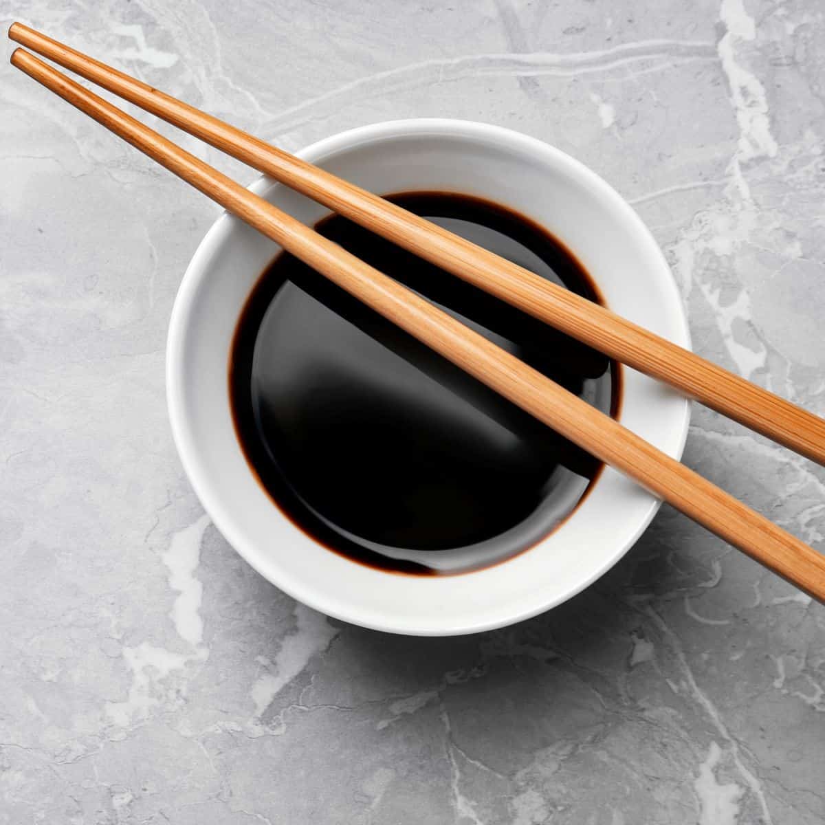 bowl of tamari sauce with chopsticks laying across. For tamari substitutes