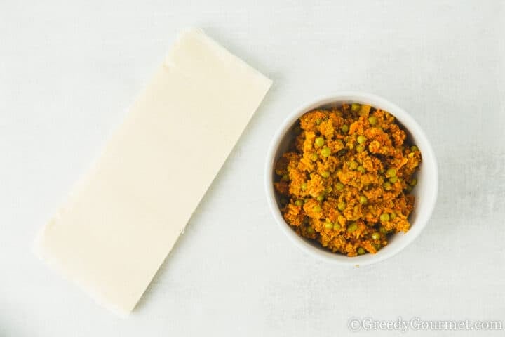 keema filling in a bowl next to pastry.