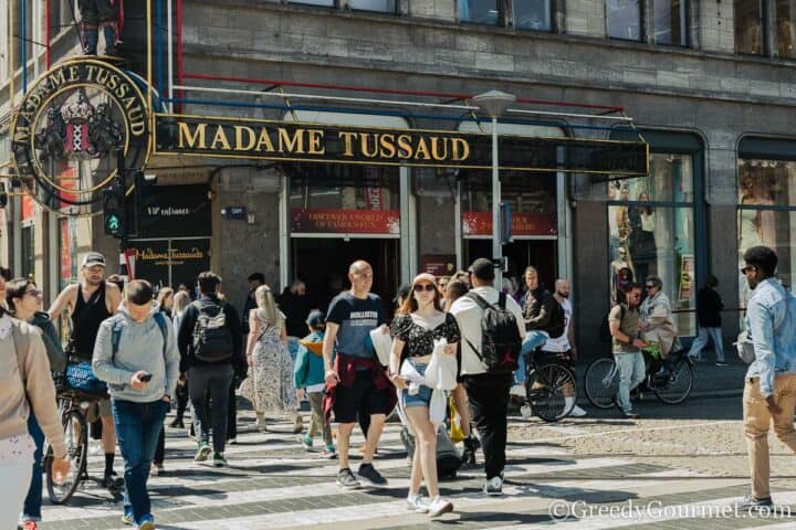 People walking on the street outside Madame Tussaud building.