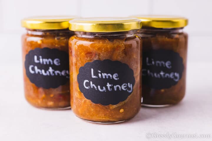 3 jars of lime chutney lined up with black labels.