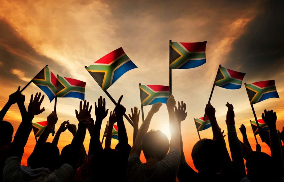 people holding South Africa flags.