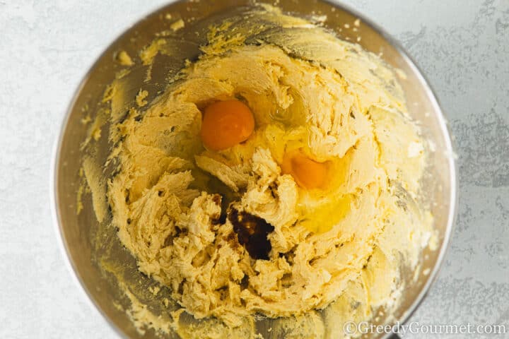Add egg and vanilla to a bowl of dough.