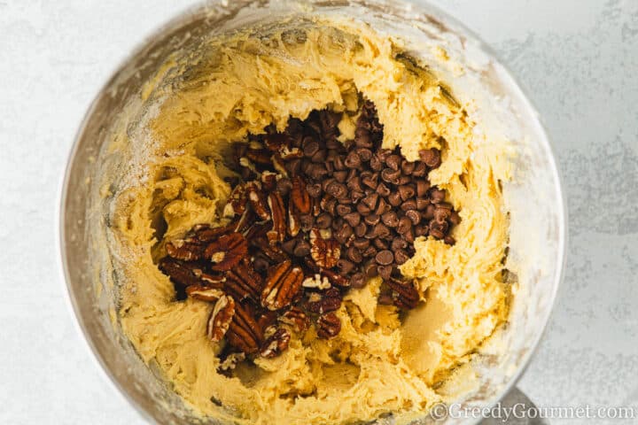 Add pecans and chocolate chips to cookie dough. 