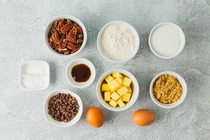 Ingredients for pecan cookies in small bowls on a table.