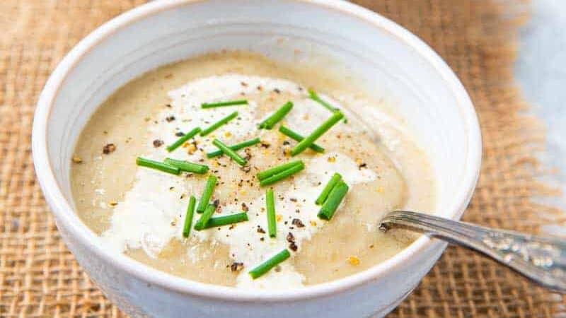 Three bowls filled with Jerusalem artichoke Soup with spoons in them.