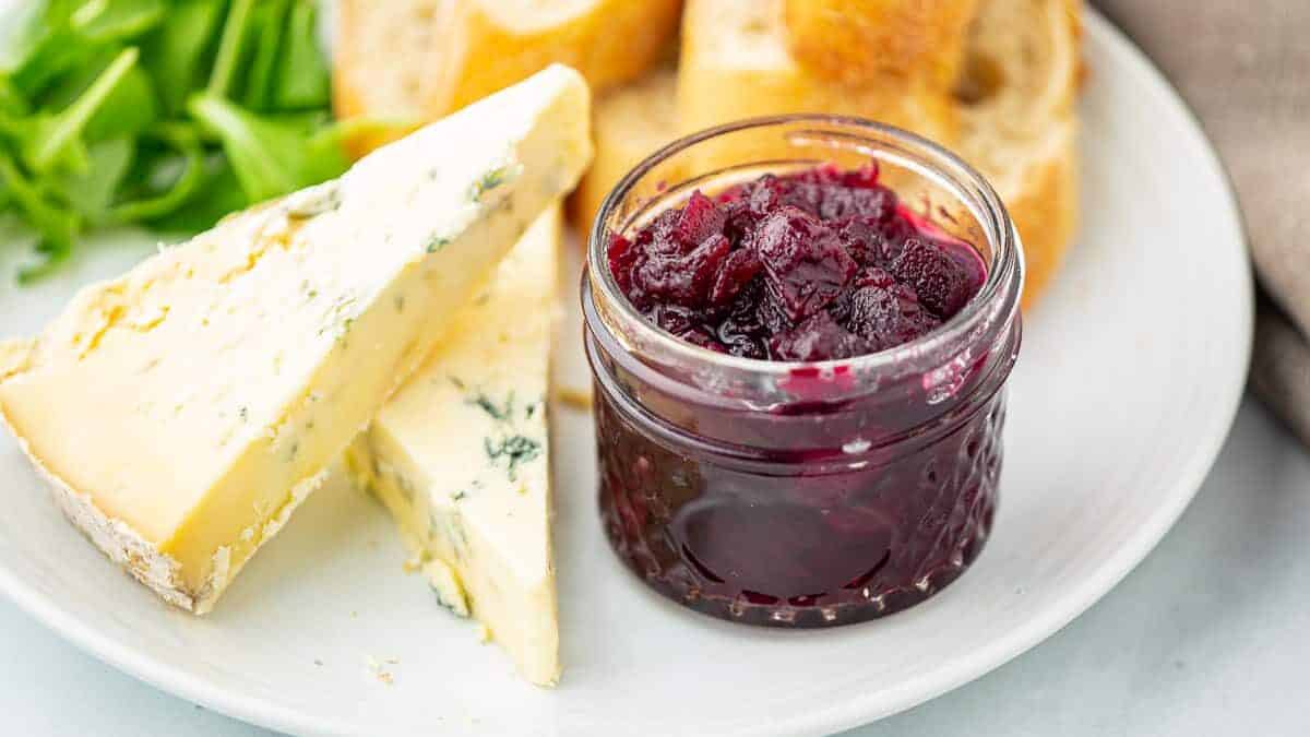 Close up of a purple chutney and slices of cheese