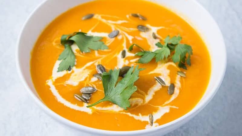 A bowl of orange pumpkin and sweet potato soup