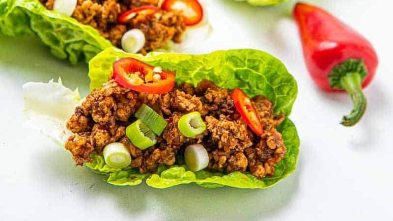 Close up of lettuce meat cups with red peppers as garnsih