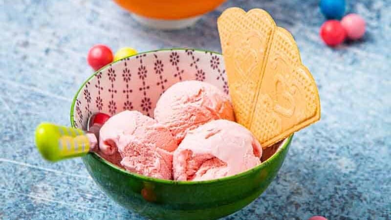 Two bowls of pink ice cream with wafers
