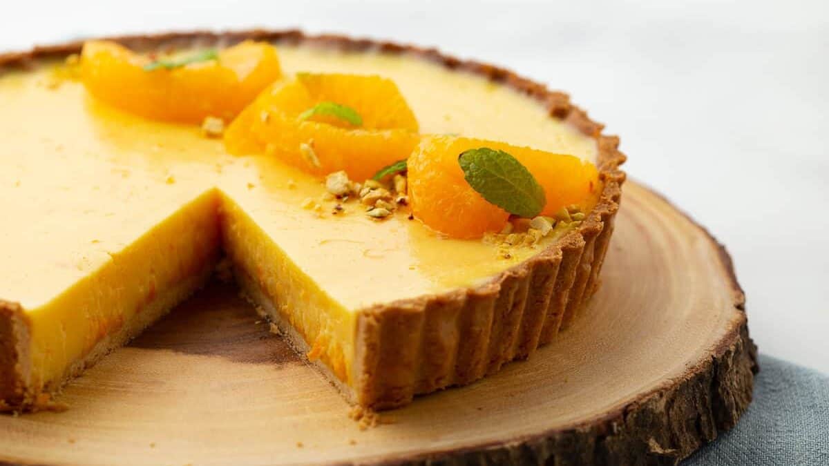 Close up of an orange tart with a slice removed