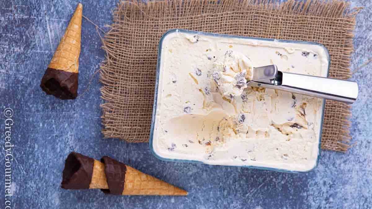 Fresh raisin ice cream in a glass container and ice cream cones