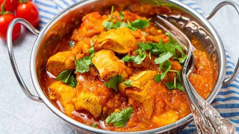 Bowl of chicken pathia and naan bread