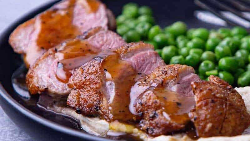 Plate of pan fried duck breast with orange sauce