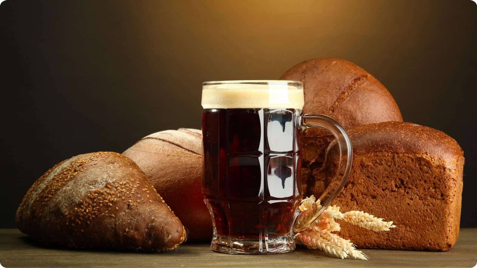 Various bread and mug of beer displayed on a brown background.