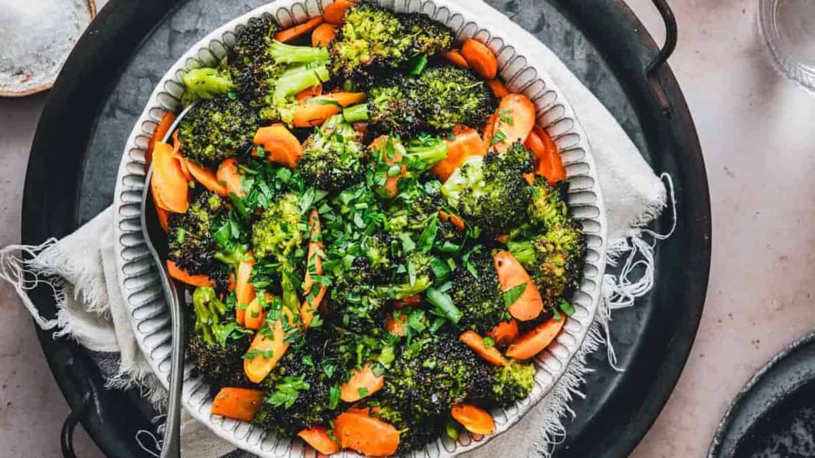 Broccoli carrots salad in a bowl over an iron cast serve on the table. 
