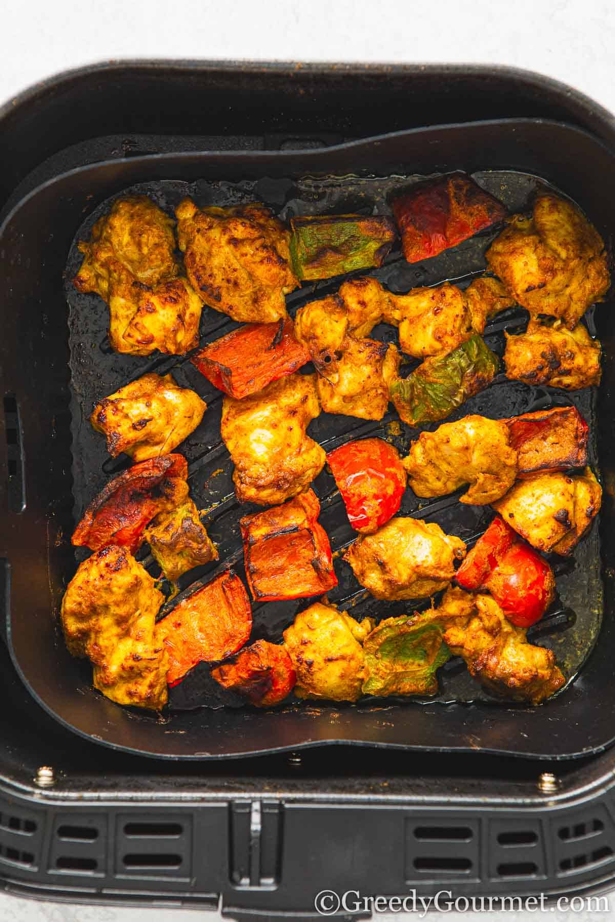 Air fryer chicken tikka in an air fryer pan.