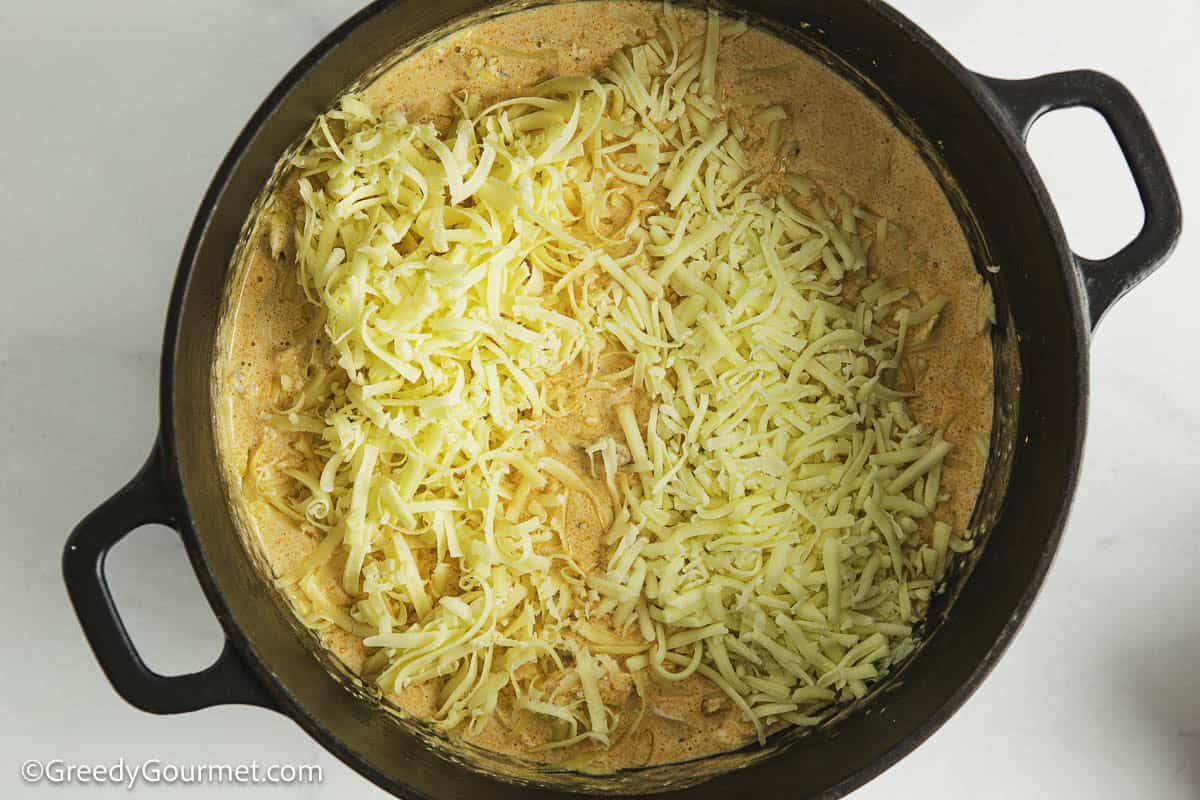 Adding cheese to a sauce.