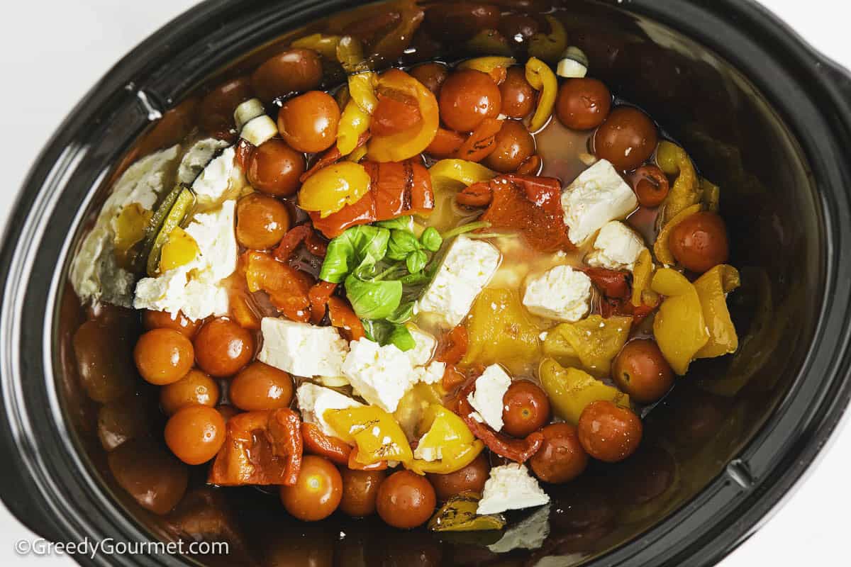 Ingredients for feta and tomato pasta in a slow cooker.