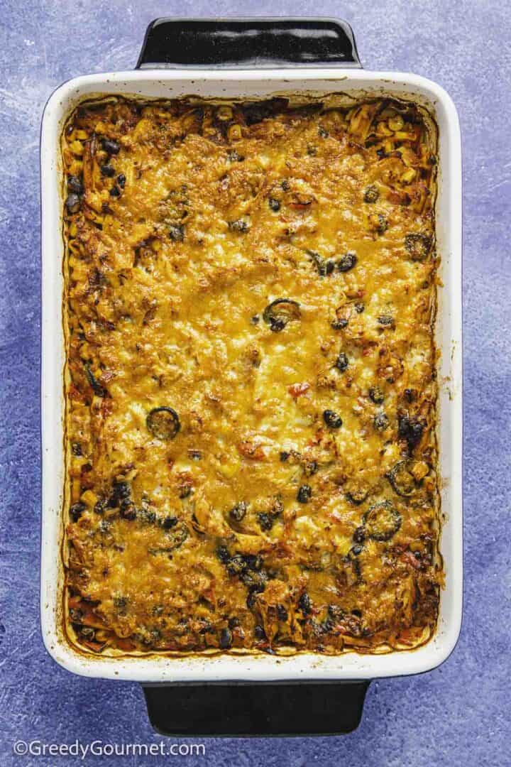 Chicken Burrito Casserole just out the oven in a white and black dish.