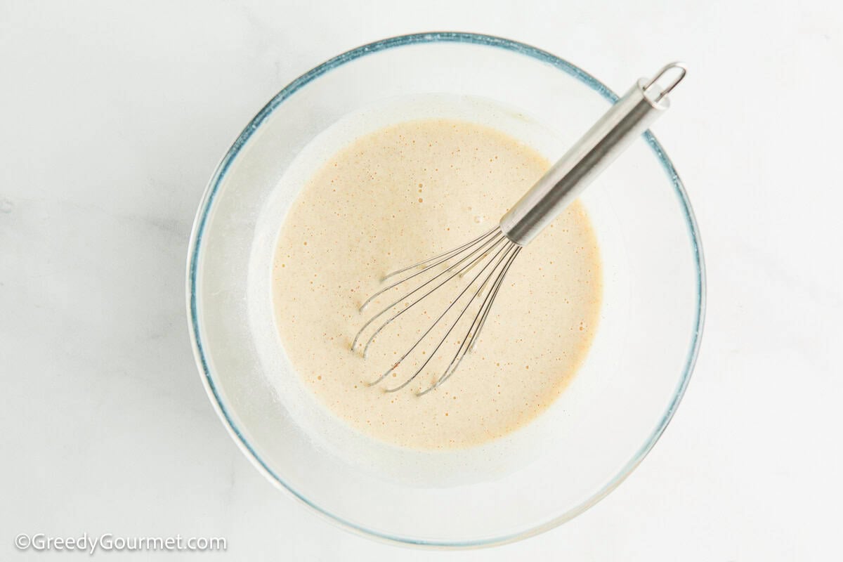 Batter and a whisk in a glass bowl.
