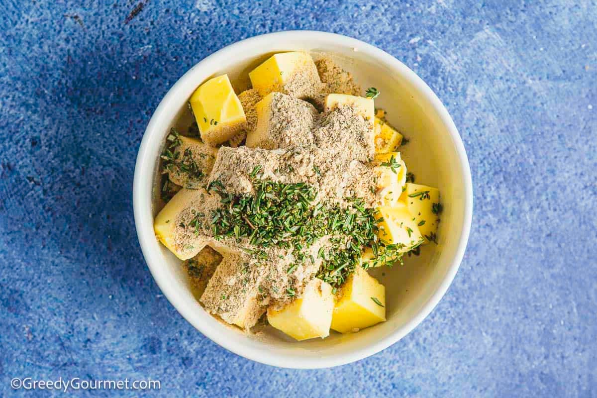A bowl of butter squares and seasonings.