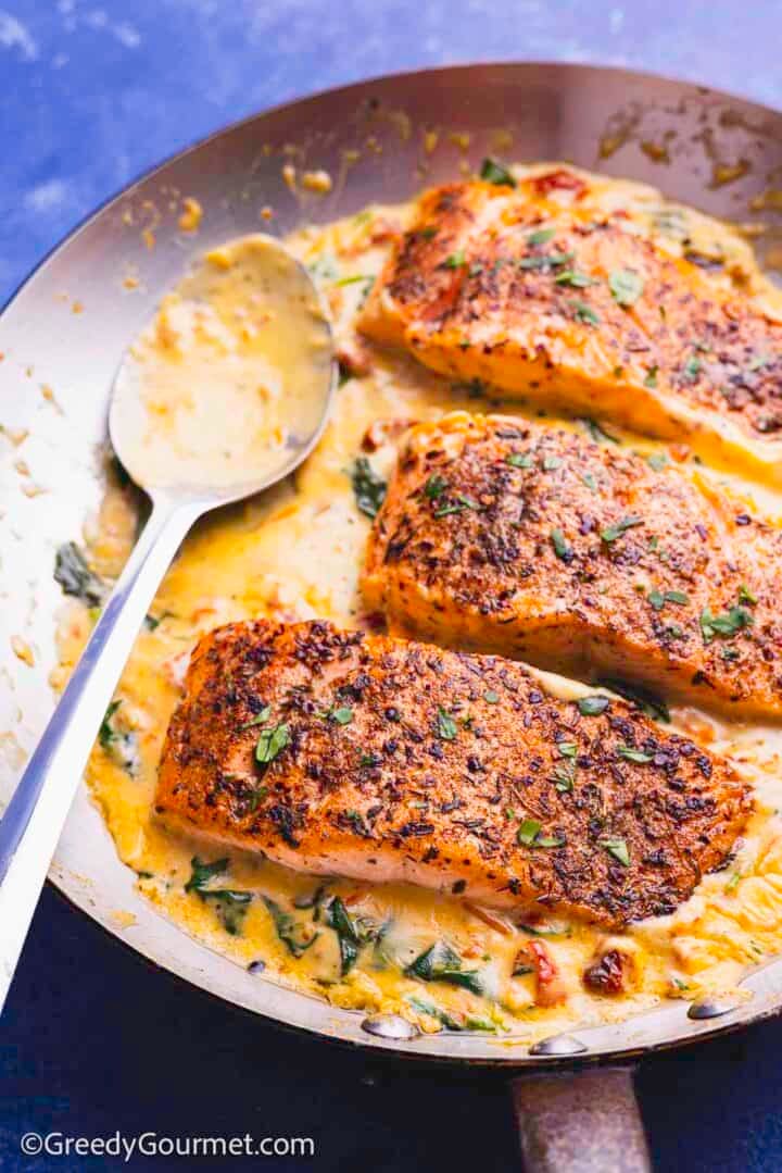 Creamy marry me salmon in a pan.