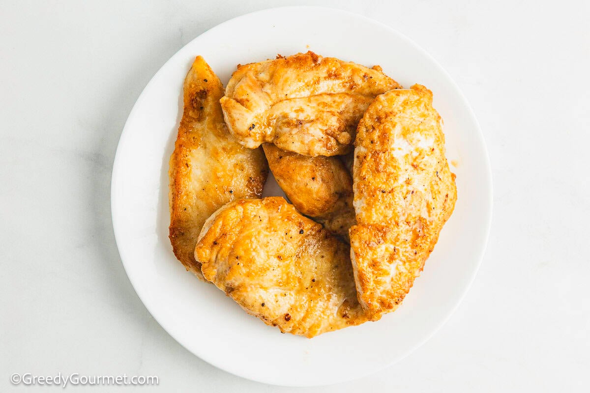 Cooked chicken breast on a plate.