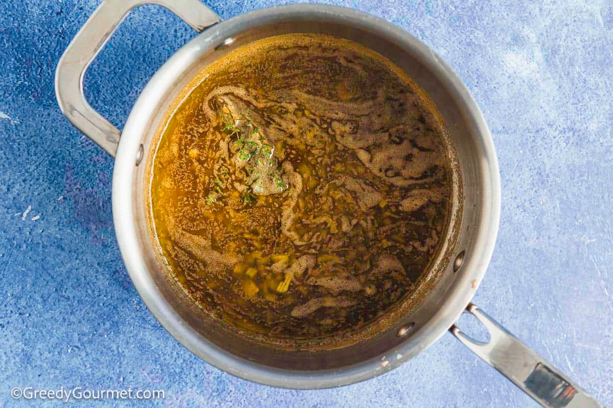 Gravy in a stainless steel pot.