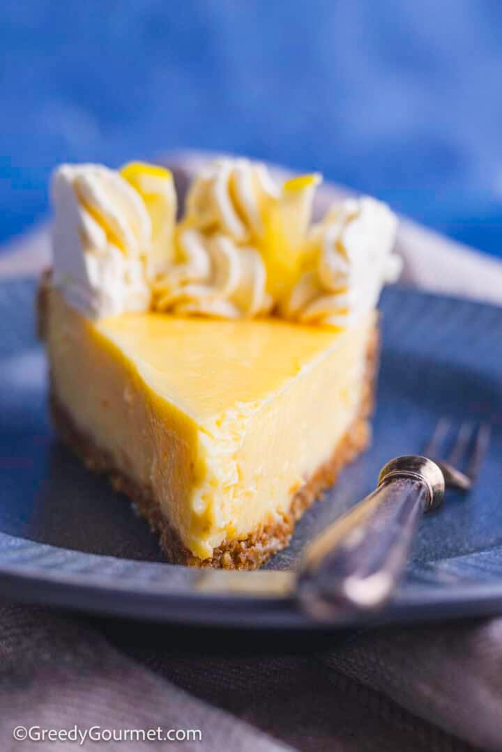 Lemon pie topped with whipped cream and lemon slices.