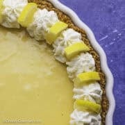 Lemon pie topped with whipped cream and lemon slices.