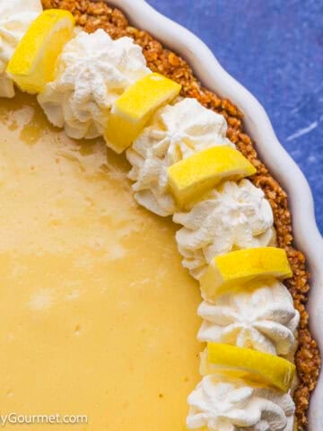 Lemon pie topped with whipped cream and lemon slices.