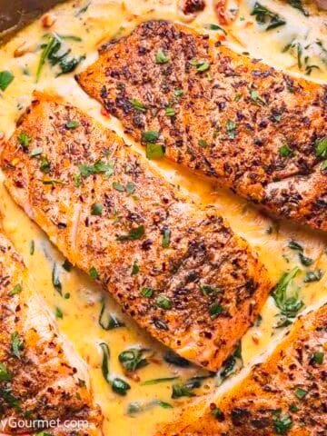 Creamy marry me salmon in a pan.