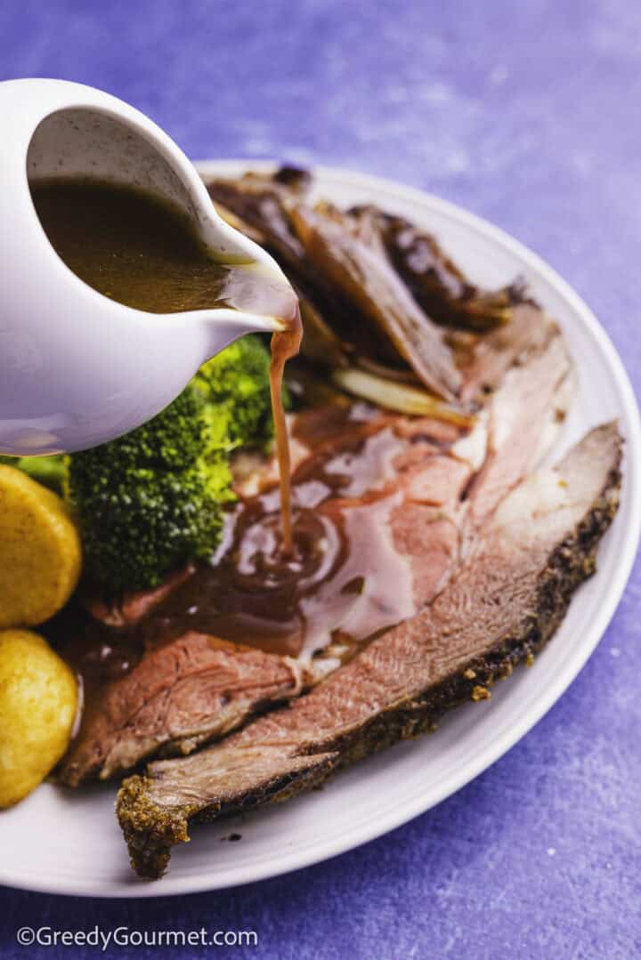 Standing Rib Roast being drizzled with gravy.