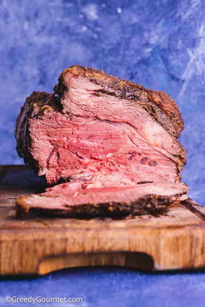 Standing rib roast on a wooden cutting board.